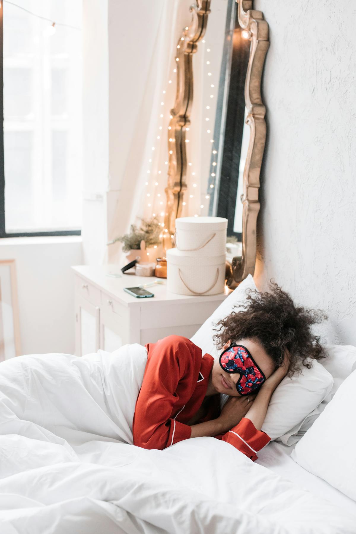 A woman sleeping with an eye mask in bed, evoking the brain's overnight cleanup during deep sleep.