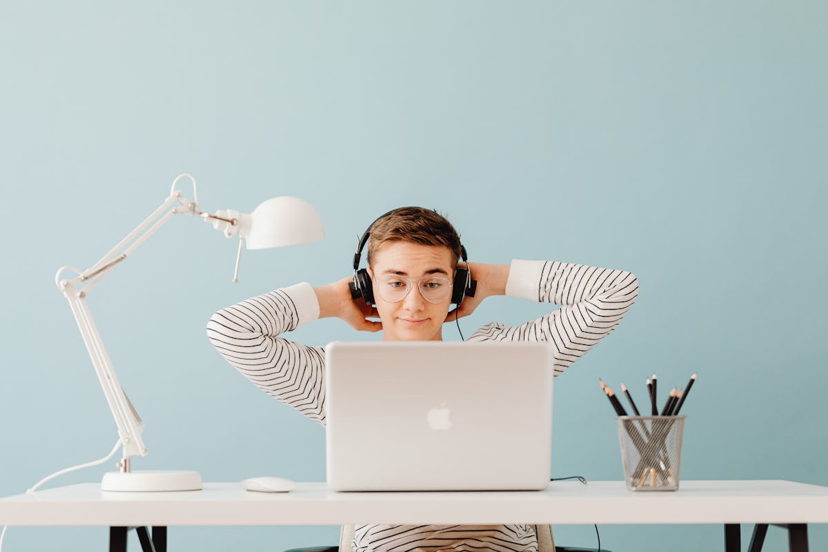 A young adult in glasses focused on his laptop screen, illustrating screen-related eye strain.