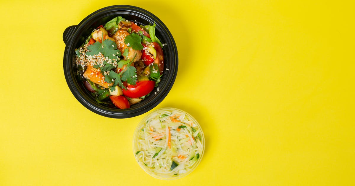 Colorful vegetable salad in a bowl with a yellow background for healthy eating