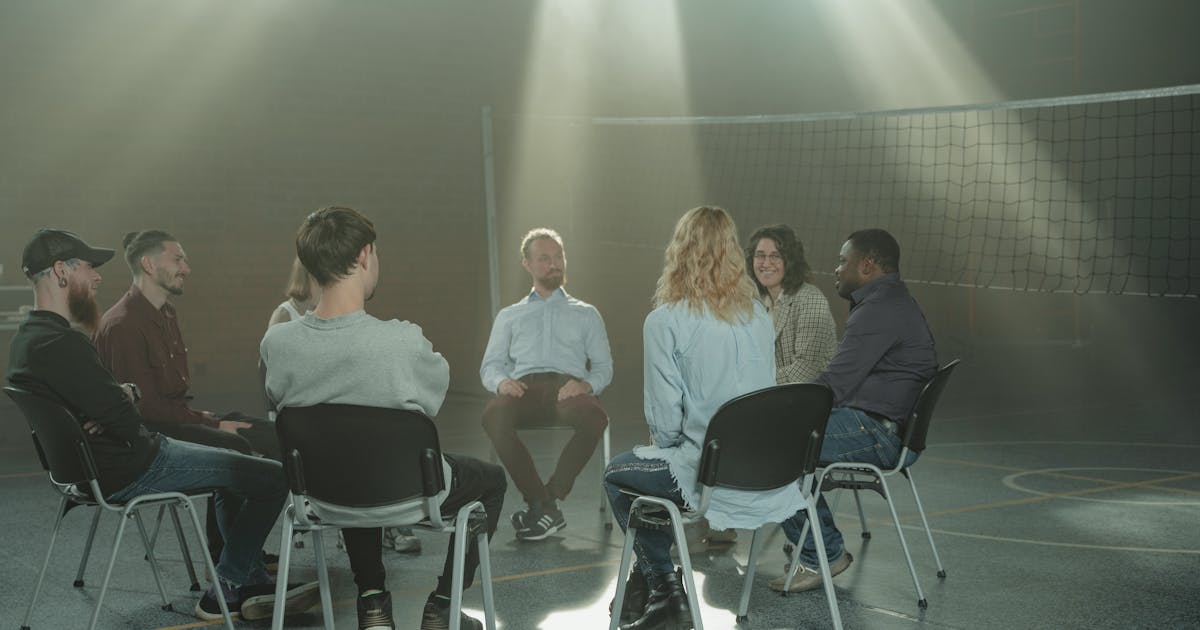 A small group engaging in a therapy session indoors, under rays of sunlight