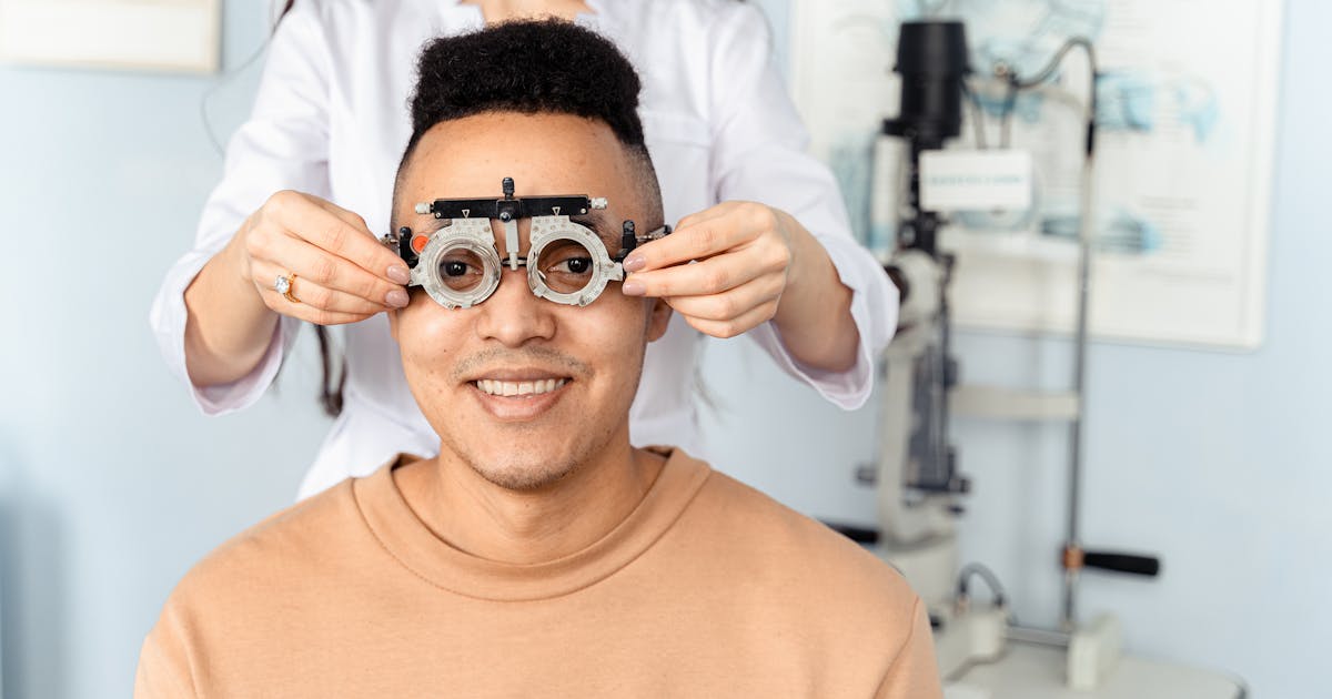 A man receiving an eye exam with a phoropter in an optometry clinic setting
