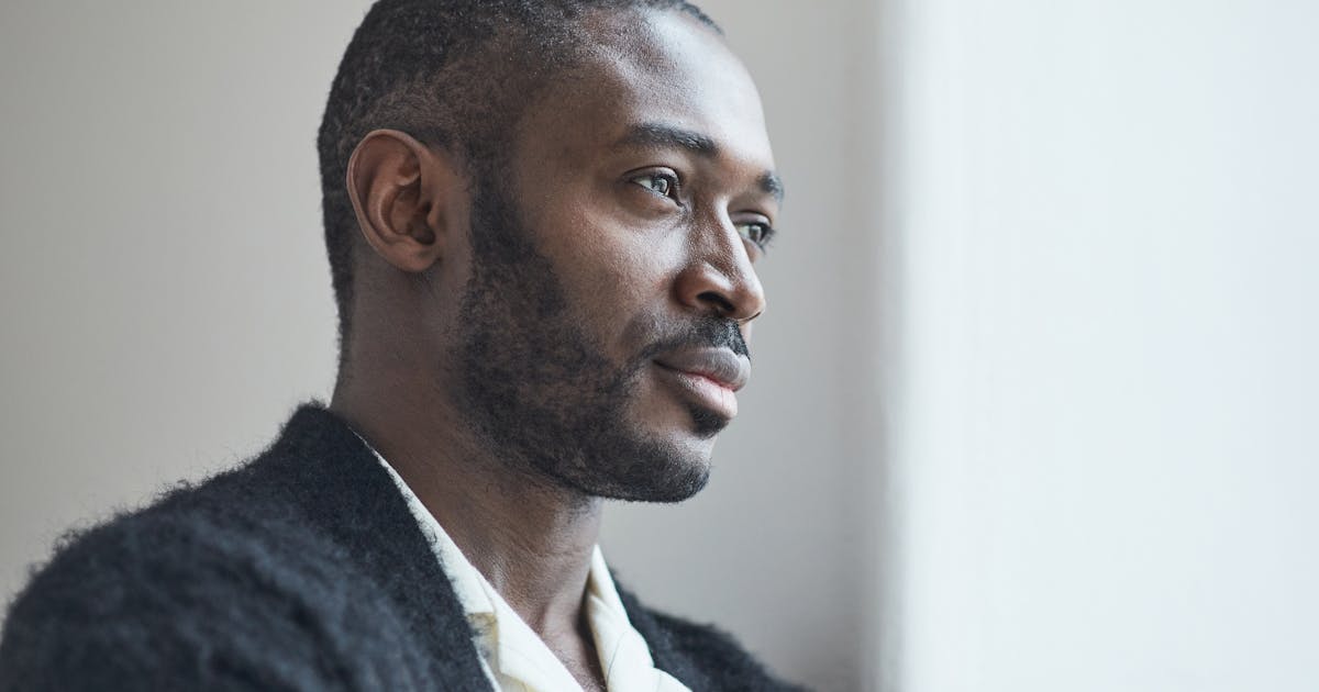 Portrait of a thoughtful adult man gazing out a window invoking deep reflection