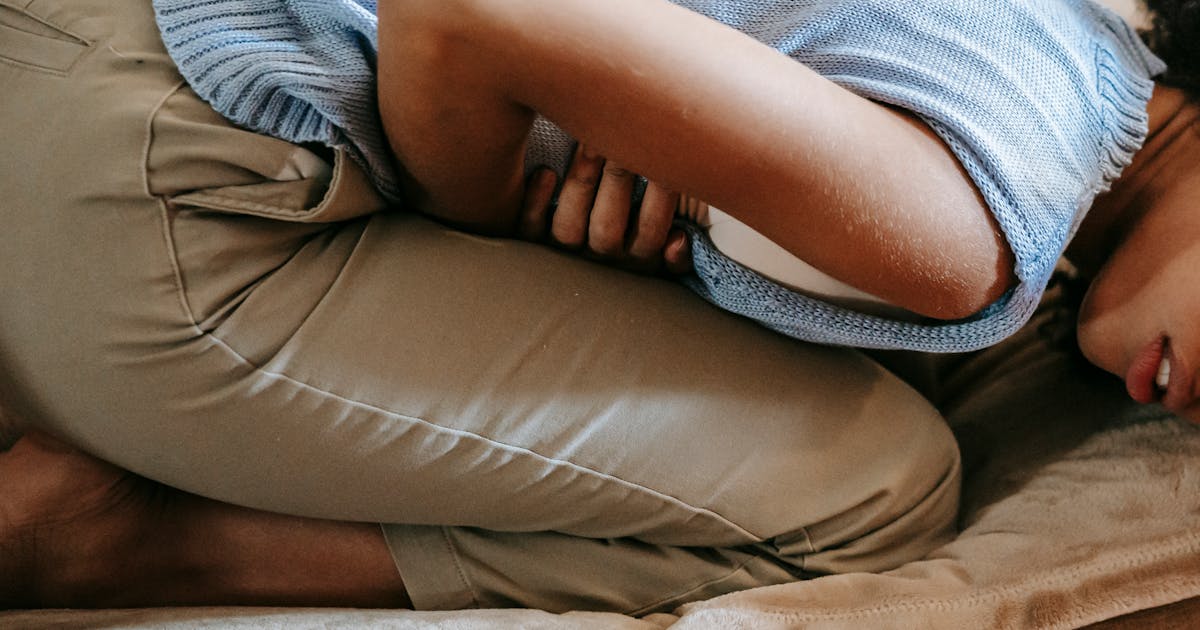 A woman holding her stomach in discomfort
