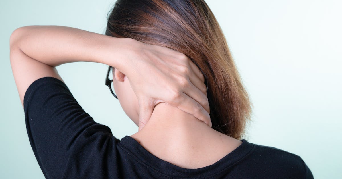 A woman resting her hand on her neck