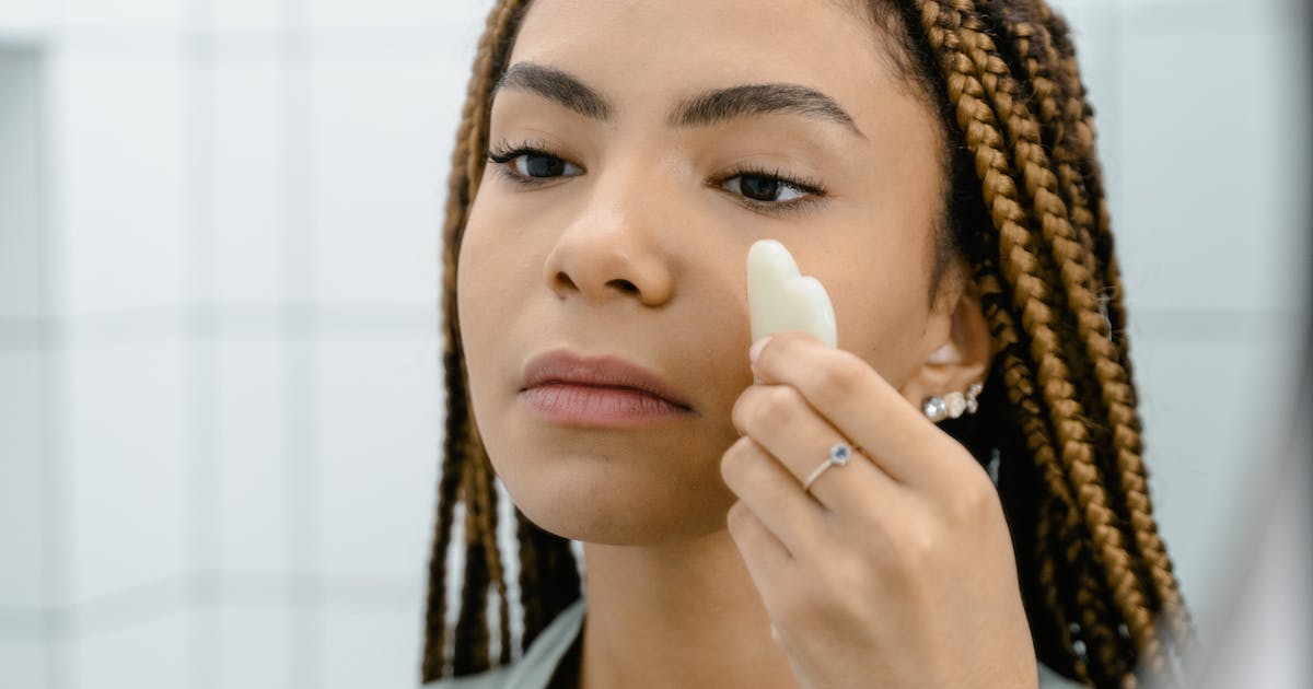 A woman examining her facial skin in a mirror