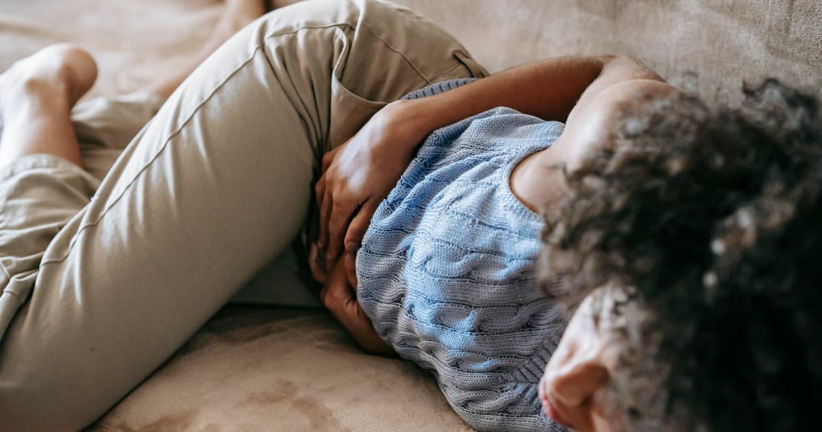 A woman holding her stomach in discomfort
