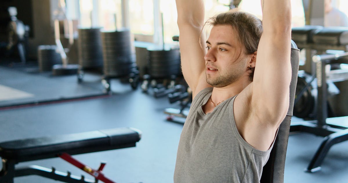A man exercising with weights at a gym