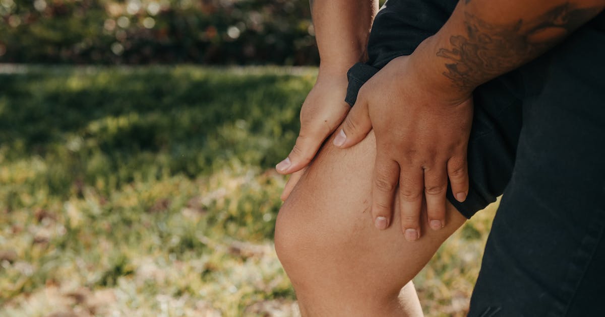 Person holding their leg in discomfort