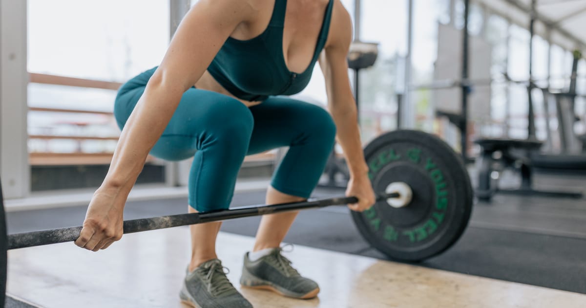 Woman lifting a barbell in a gym
