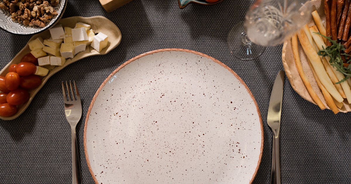 Empty dinner plate and cutlery on a table representing closing the kitchen for the evening