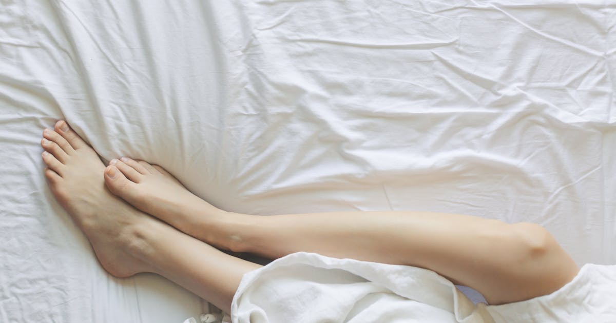 Person in bed covered with a blanket in a calm bedroom