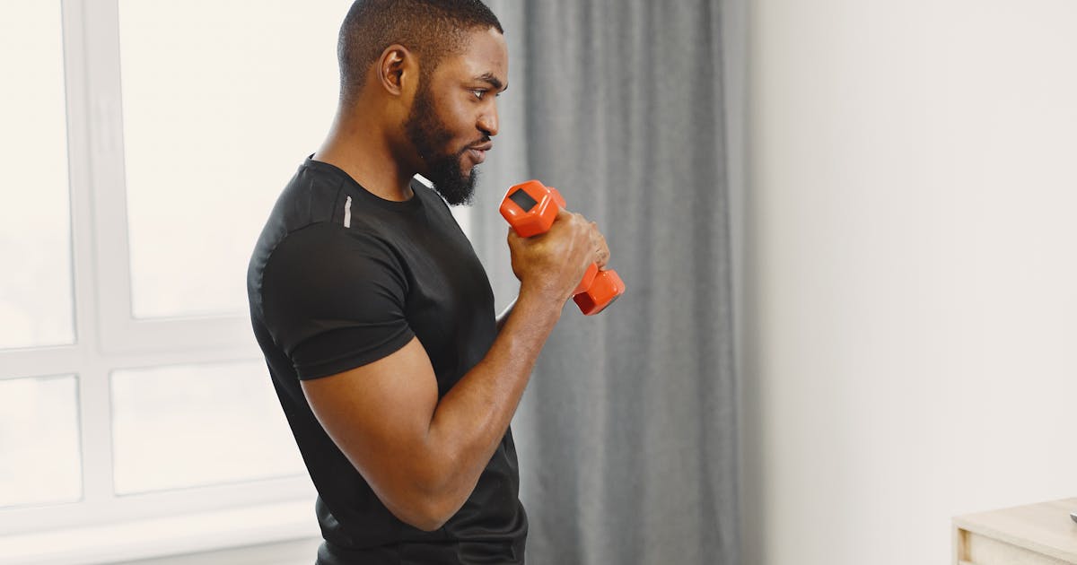 Middle-aged man checking workout log in home gym