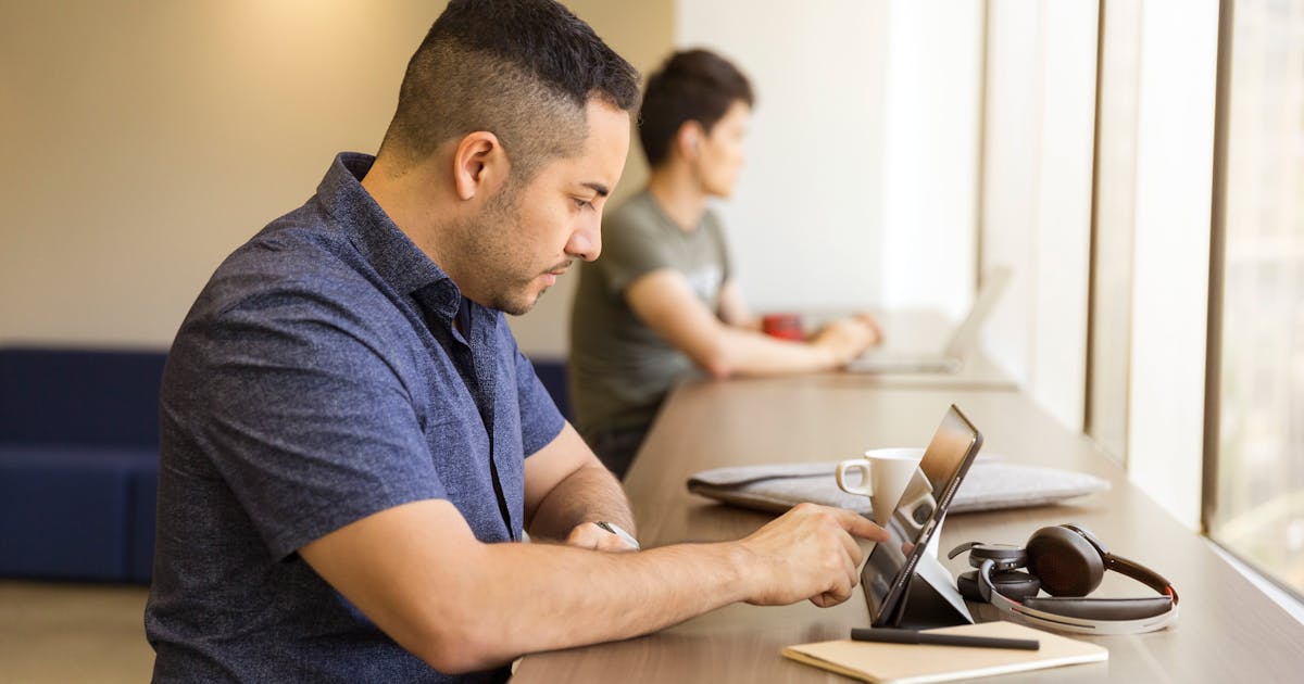 Person at desk with phone face down focused on single open document