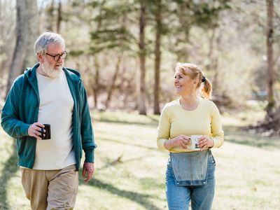 Happy elderly couple walking outdoors, sharing a joyful conversation