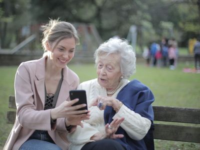 Senior mother and adult daughter sitting together at home