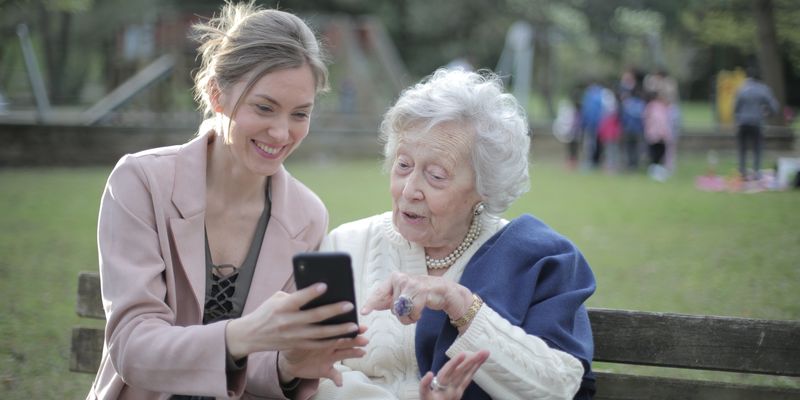 Senior mother and adult daughter sitting together at home