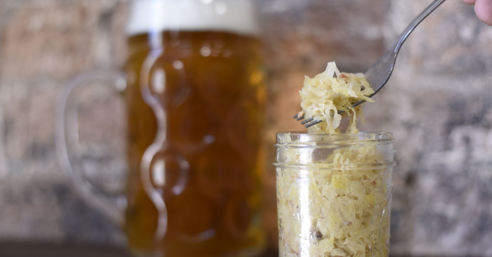 A jar of fermented sauerkraut being spooned