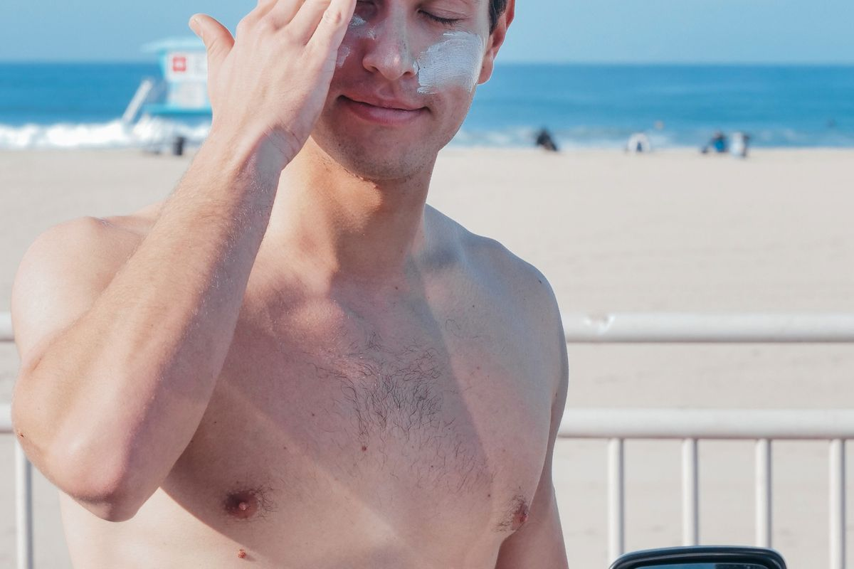 A man applying sunscreen to his face