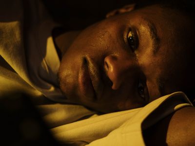 A man lying awake in bed at night with his eyes open