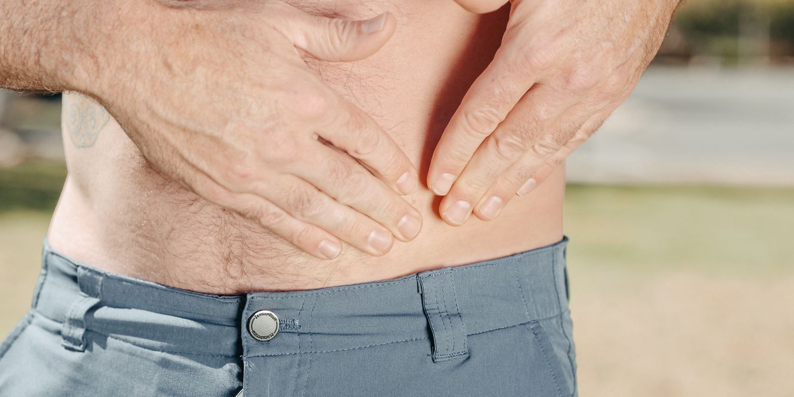 A person pressing both hands against the upper abdomen
