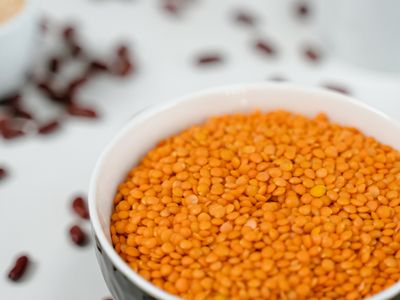A bowl of red lentils, an iron rich food, on a dark table