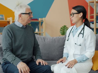 An older man in conversation with a doctor in a white coat during a consultation