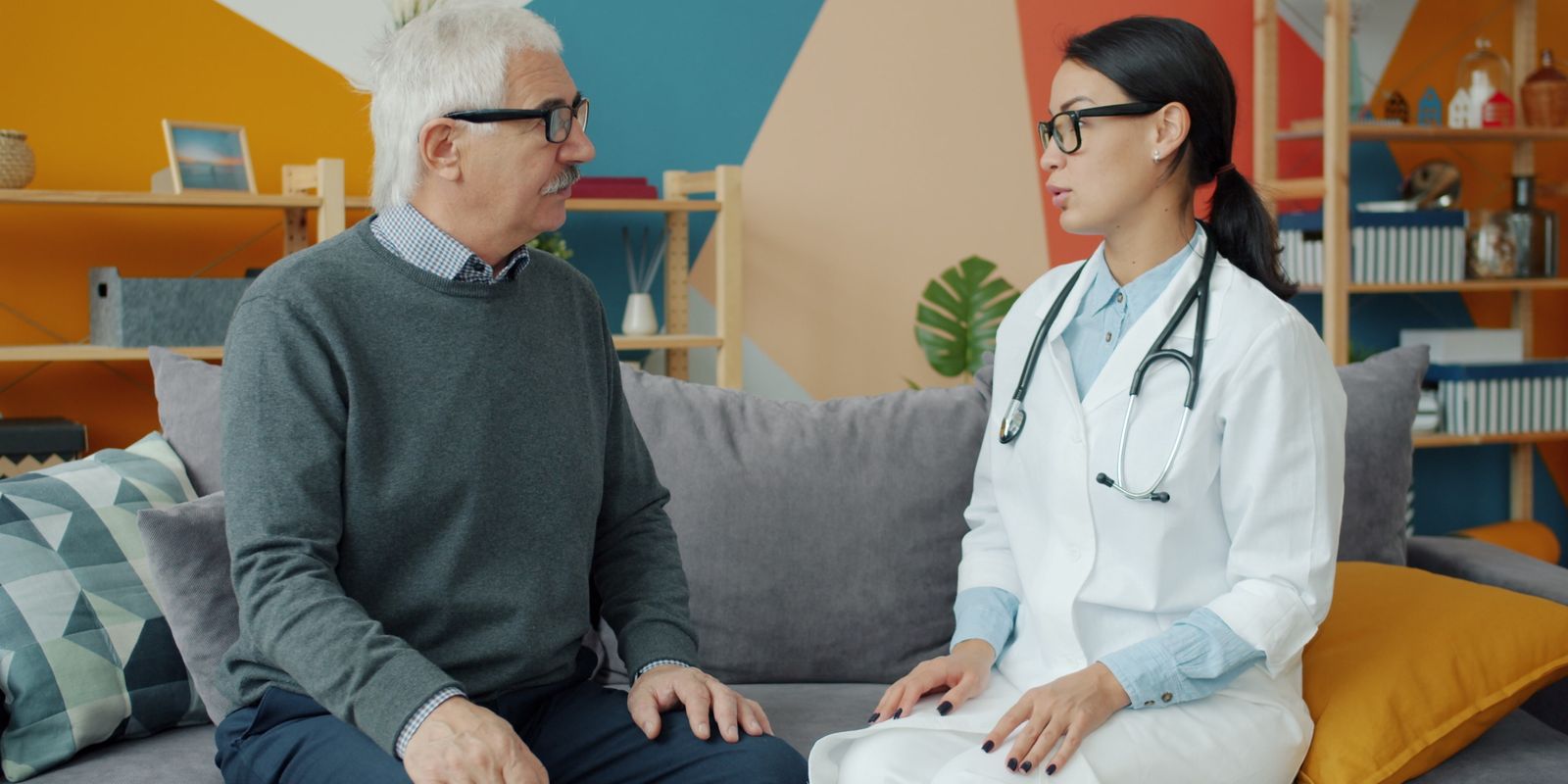 An older man in conversation with a doctor in a white coat during a consultation