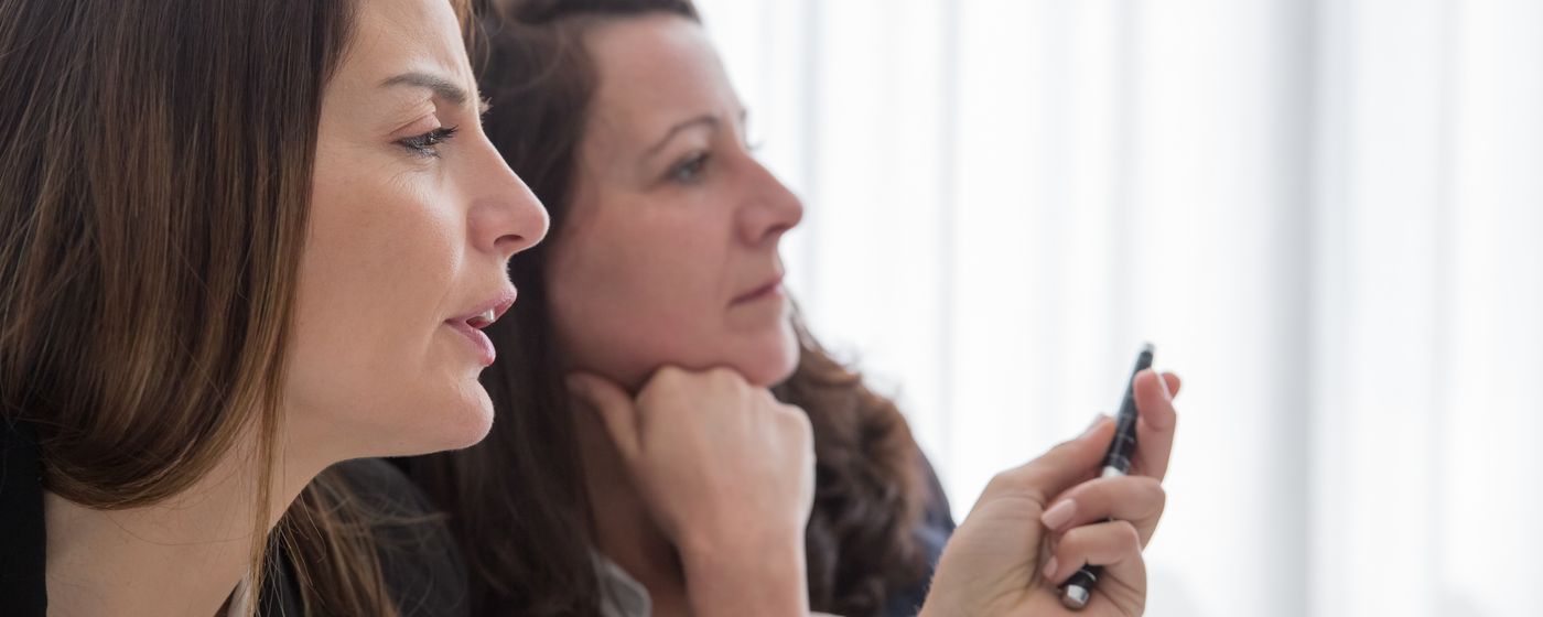 Two women sitting face to face in conversation in a bright room