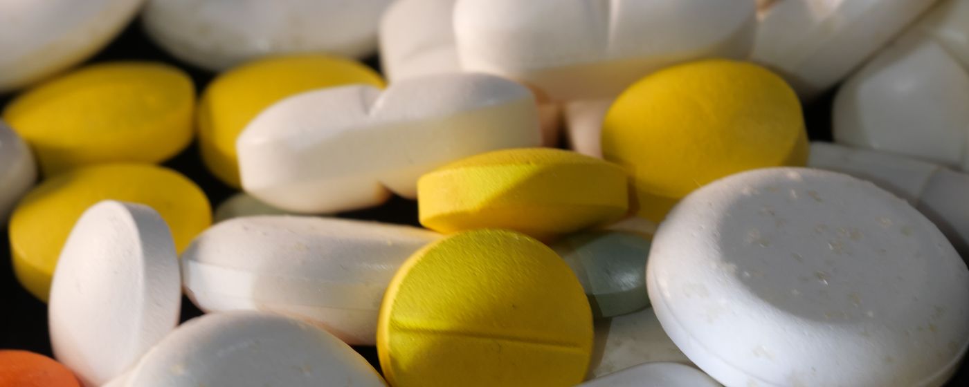A close up of white and yellow tablets of several different shapes and sizes