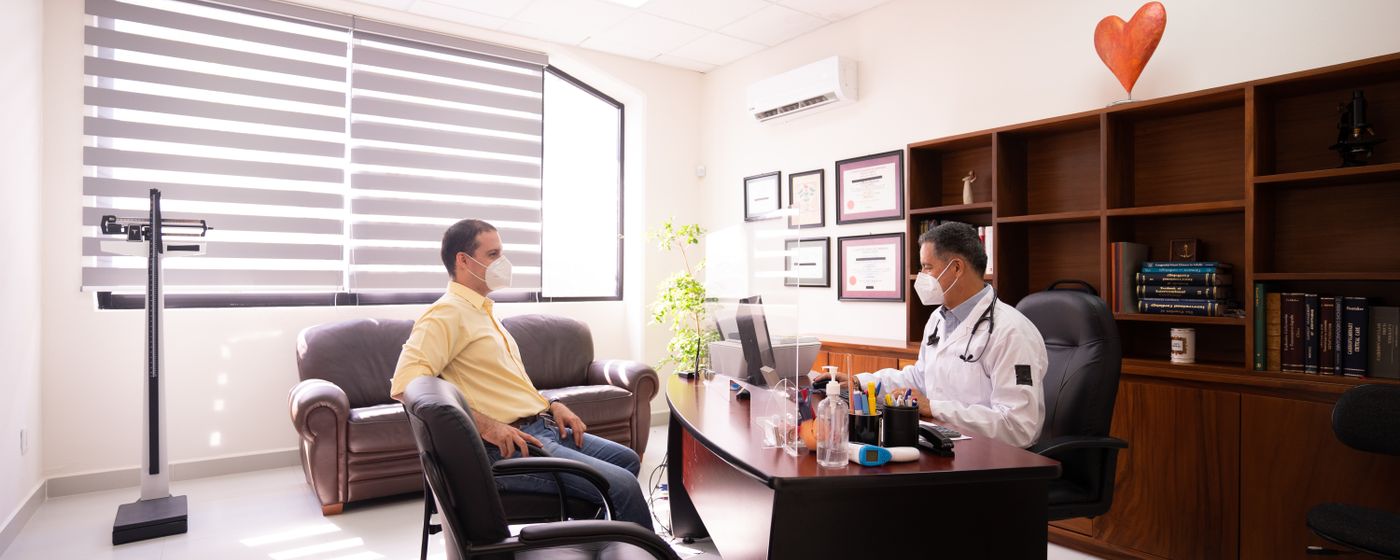 An older man sitting across from a doctor during a consultation in a medical office