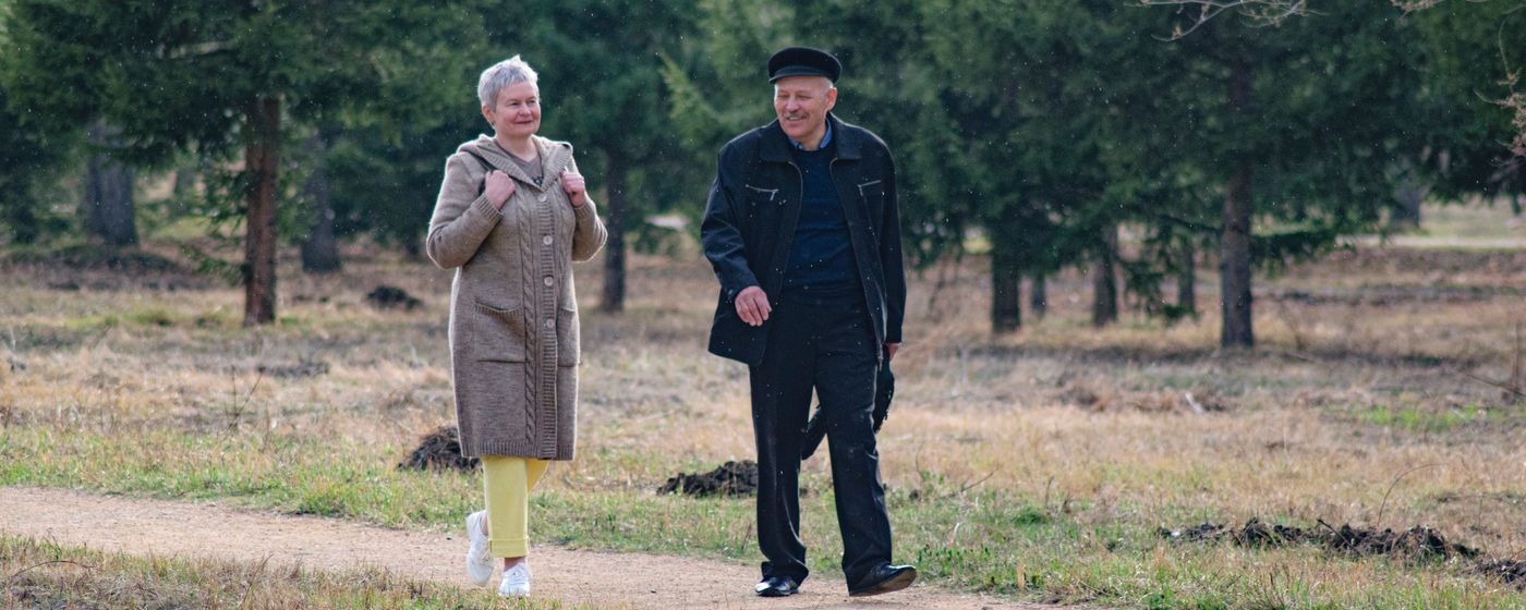 A senior couple walking together along a park path