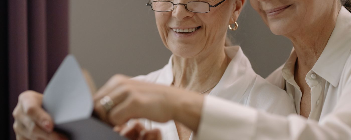 Two older women reading a letter together at home