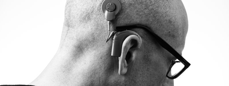 Close-up of a behind-the-ear hearing aid worn by an older adult