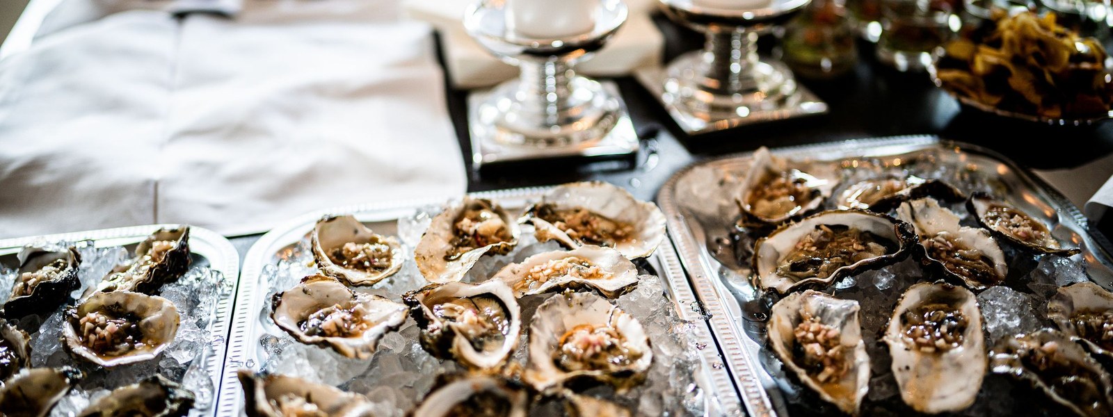 Trays of fresh oysters on ice arranged on a table