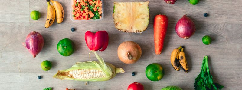 A spread of colorful fresh fruits and vegetables arranged on a wooden table