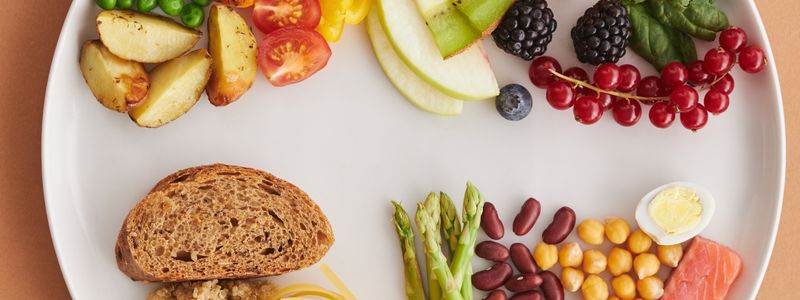 A plate of protein-rich foods including salmon, egg, chickpeas, beans and nuts