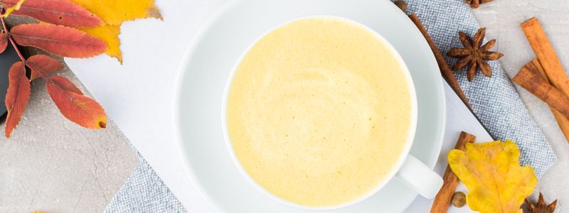 A cup of golden turmeric latte with cinnamon and spices