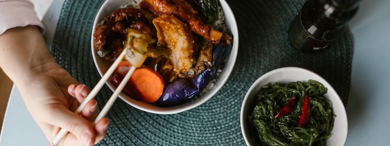 A rice-and-vegetable bowl beside a small dish of green seaweed salad