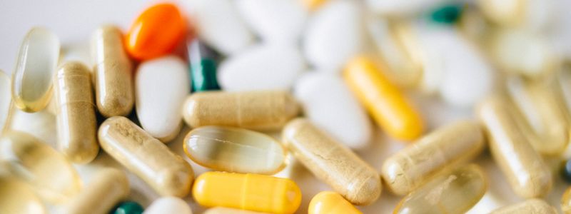 An assortment of capsules and tablets scattered on a light surface