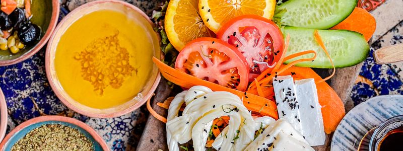 An overhead Mediterranean spread of vegetables, feta, olives and hummus