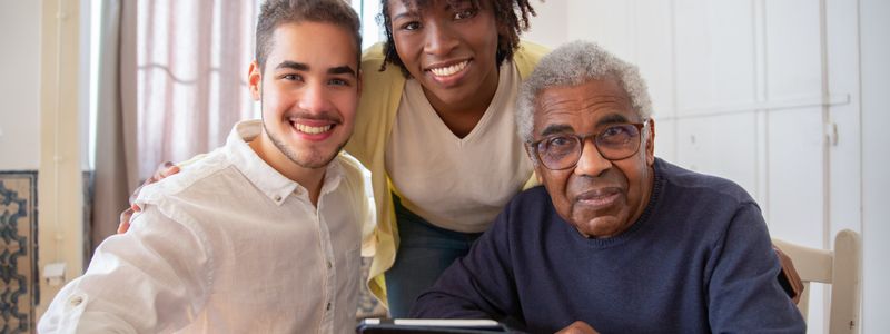 Three generations of a family sitting and laughing together at home