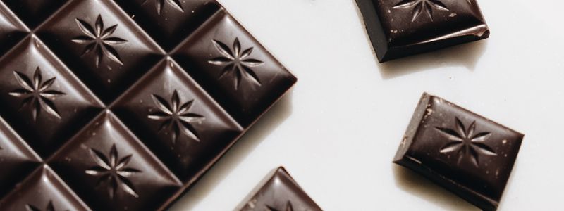 Close-up shot of a dark chocolate bar on a white surface
