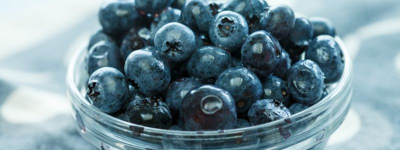 Fresh blueberries in a clear glass bowl