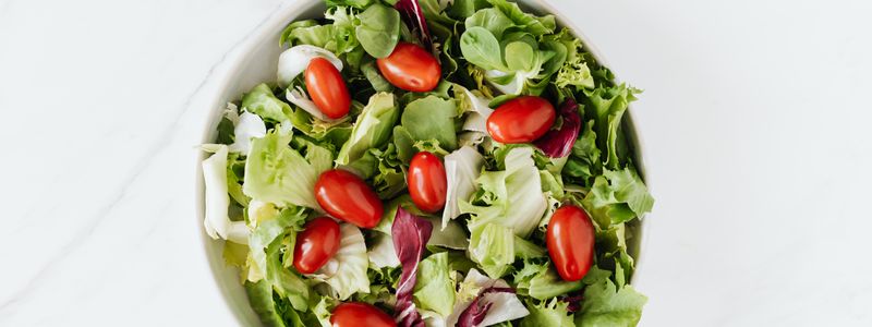 Bowl of fresh vegetable salad on table