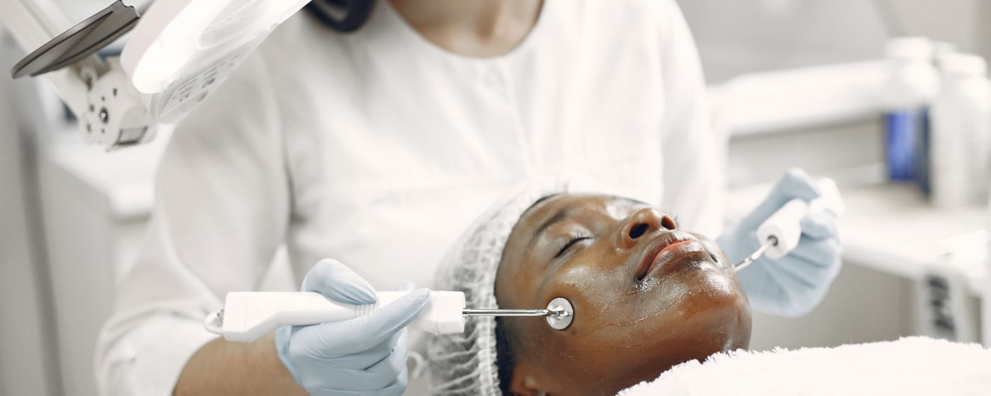 Dermatologist performing facial treatment on a relaxed patient
