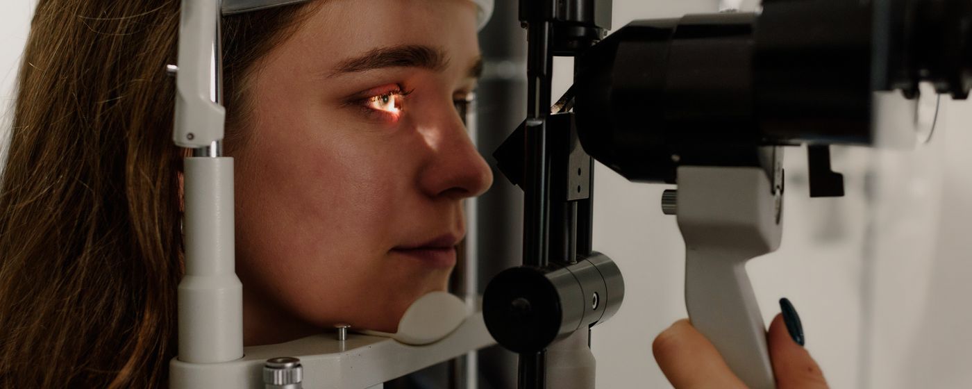 Side view of a patient looking at the light of a slit lamp during an eye exam