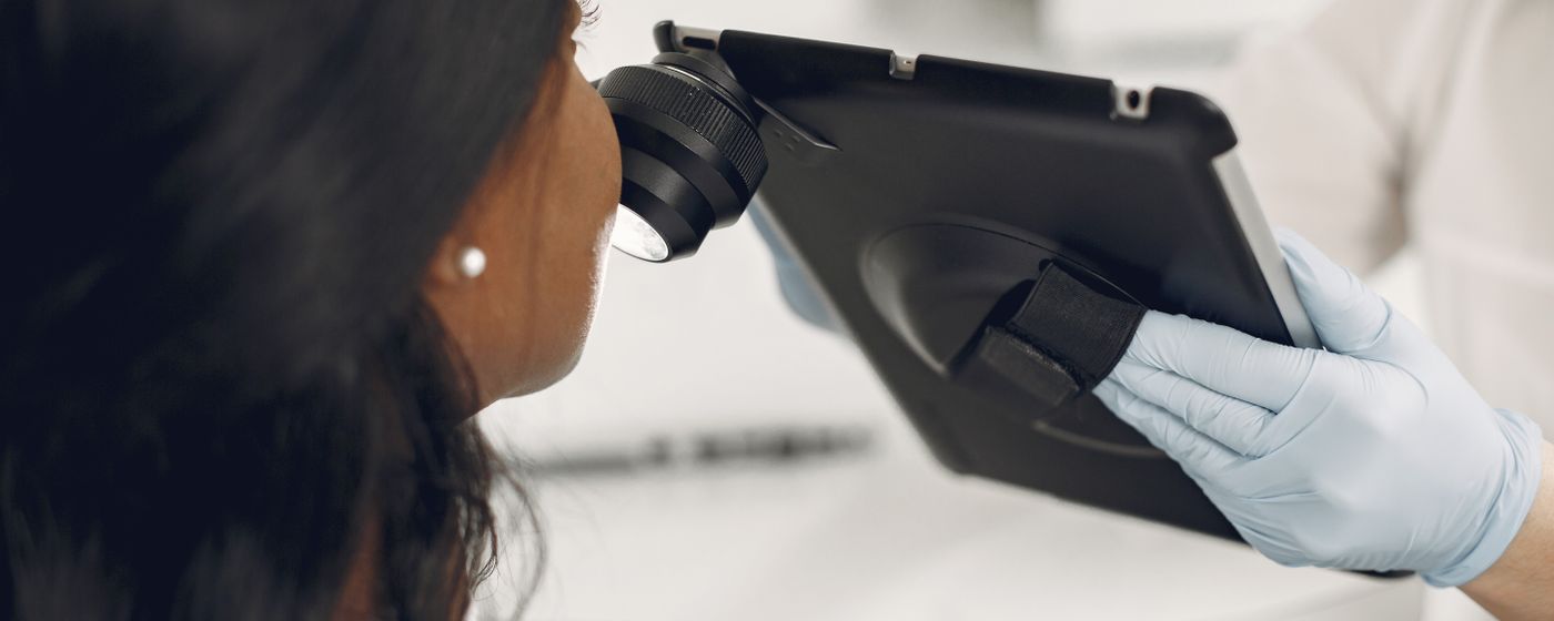 Dermatologist examining a patient's skin using a digital dermatoscope