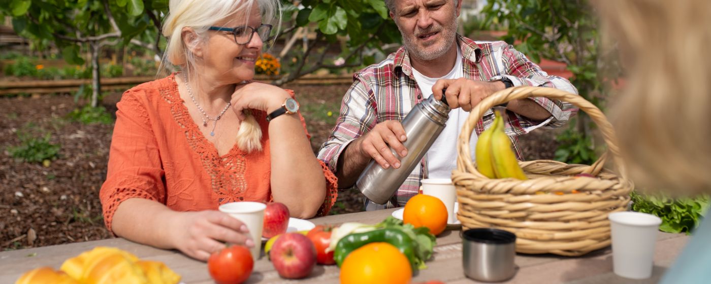 Happy senior couple having a relaxing picnic with fresh fruit