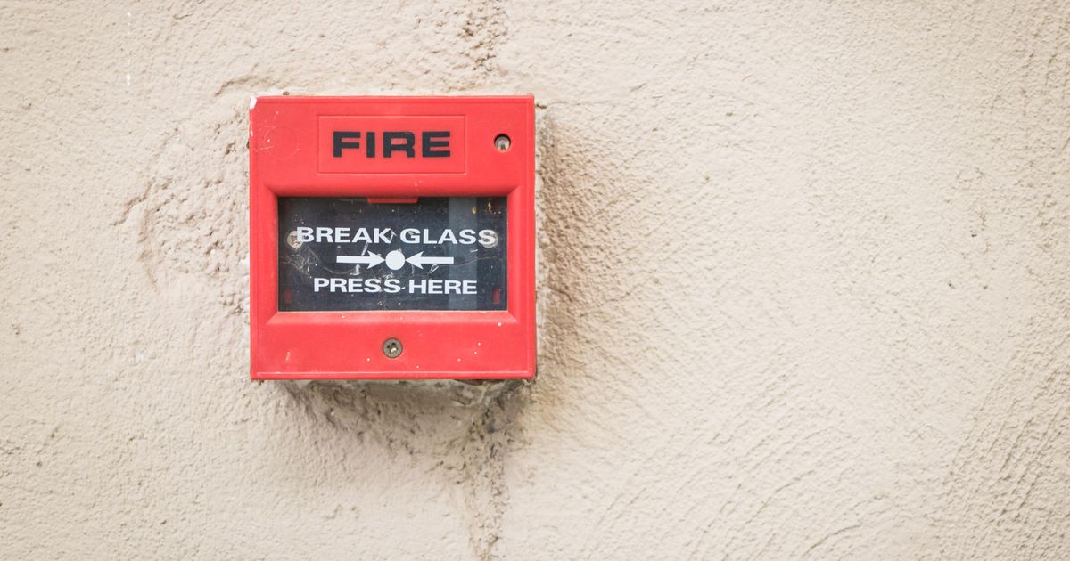 Red fire alarm control station mounted on a wall