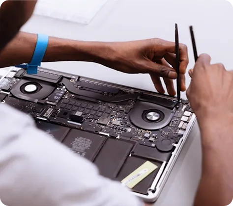 Technician using tools to repair or inspect the internal components of a laptop.
